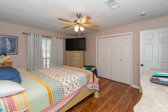 bedroom featuring ceiling fan, a closet, dark wood-type flooring, and a textured ceiling