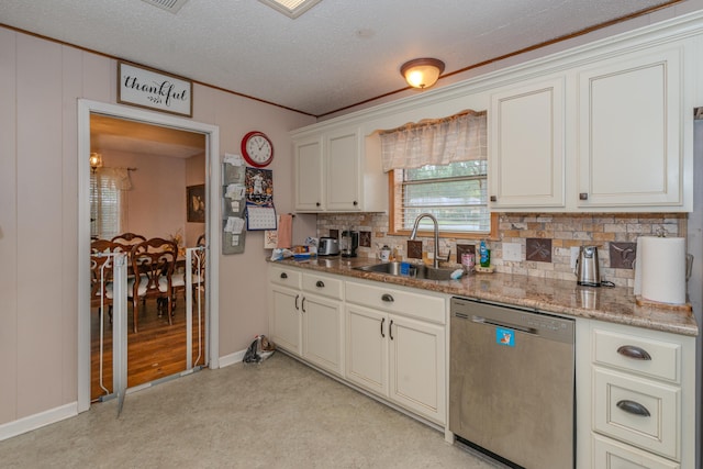 kitchen with light stone countertops, dishwasher, sink, a textured ceiling, and white cabinets