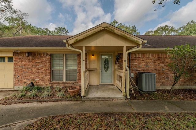 property entrance with central air condition unit and a garage