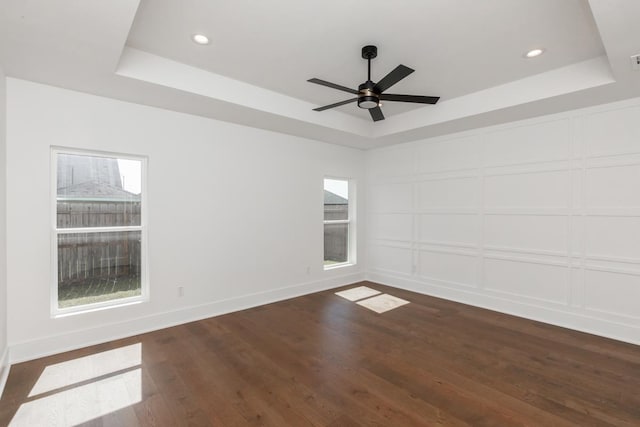 3570 Lily Ln, Beaumont, TX 77713 - spare room with a tray ceiling, dark wood-style flooring, plenty of natural light, and recessed lighting