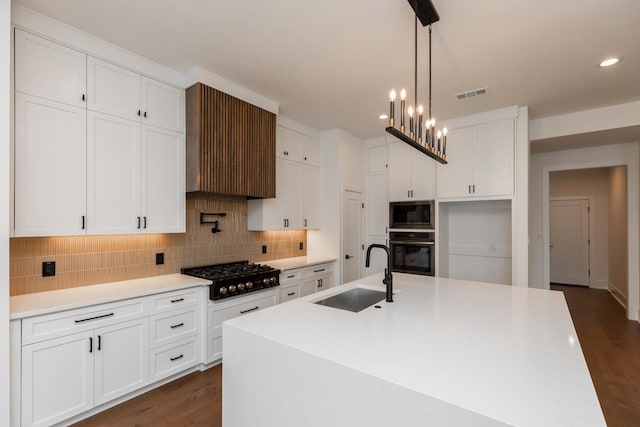 3570 Lily Ln, Beaumont, TX 77713 - kitchen featuring black appliances, a sink, tasteful backsplash, white cabinetry, and a kitchen island with sink