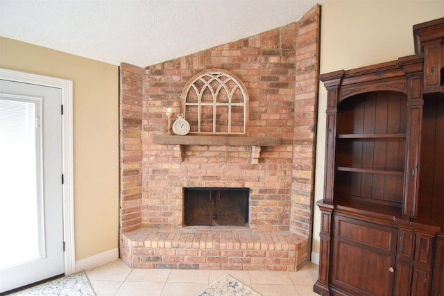 unfurnished living room with vaulted ceiling, a brick fireplace, light tile patterned floors, and a textured ceiling