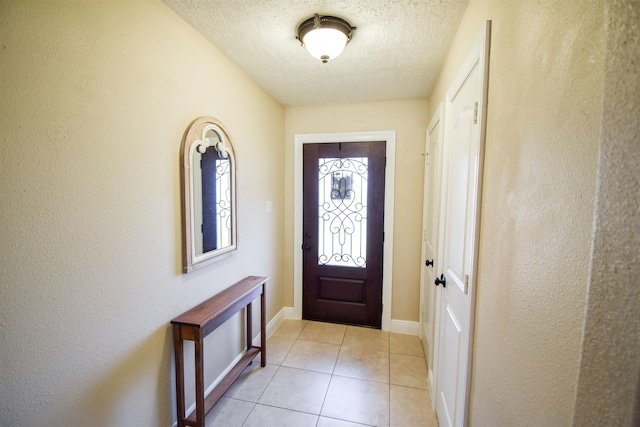 entryway with light tile patterned floors and a textured ceiling