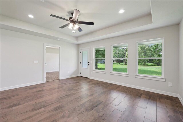 8581 Cedar Dr, Lumberton, TX 77657 - spare room featuring a raised ceiling, healthy amount of natural light, dark wood finished floors, ceiling fan, and recessed lighting