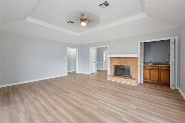 1120 Meadowvale Dr, Beaumont, TX 77706 - unfurnished living room featuring a raised ceiling, a ceiling fan, light wood-style floors, a brick fireplace, and ornamental molding