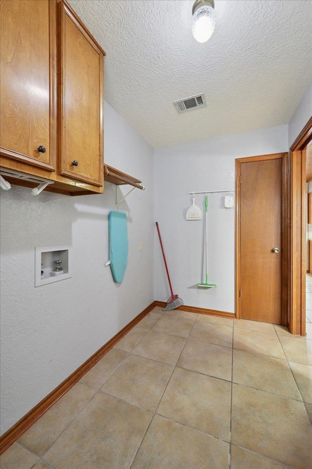 1120 Meadowvale Dr, Beaumont, TX 77706 - washroom with cabinet space, washer hookup, a textured ceiling, and light tile patterned flooring