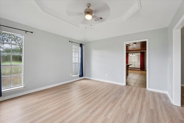 1120 Meadowvale Dr, Beaumont, TX 77706 - spare room featuring ceiling fan, light wood-style flooring, and a tray ceiling