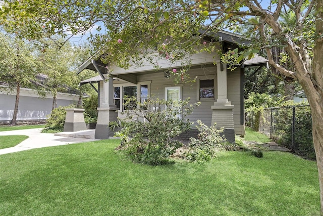 back of property featuring covered porch and a yard