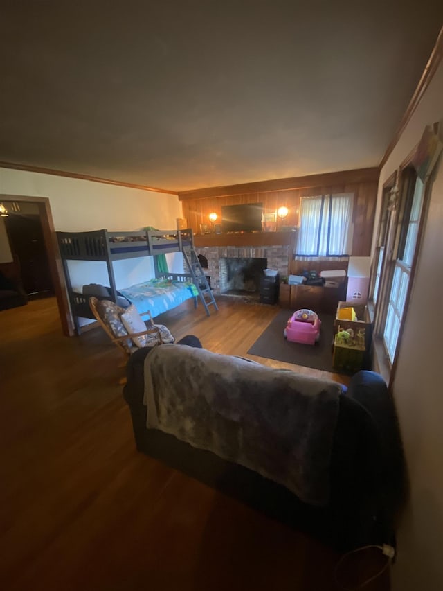 living room with hardwood / wood-style flooring, a brick fireplace, and ornamental molding