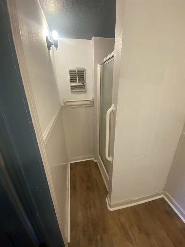 bathroom with wood-type flooring and a shower with door