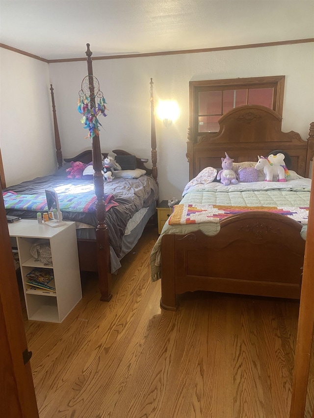 bedroom with crown molding, light hardwood / wood-style floors, and a notable chandelier