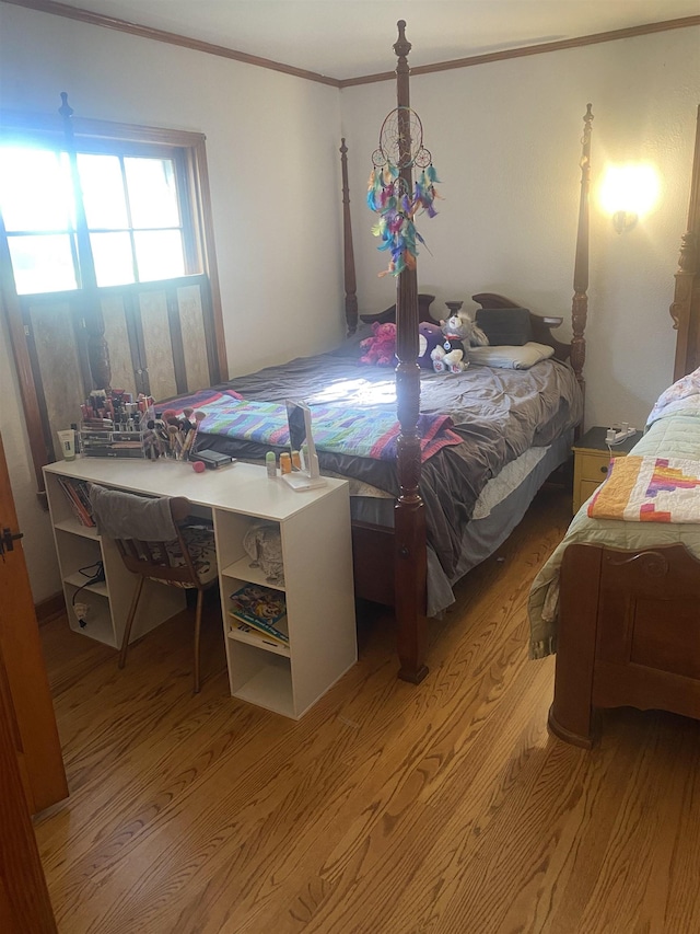 bedroom featuring ornamental molding and light hardwood / wood-style flooring