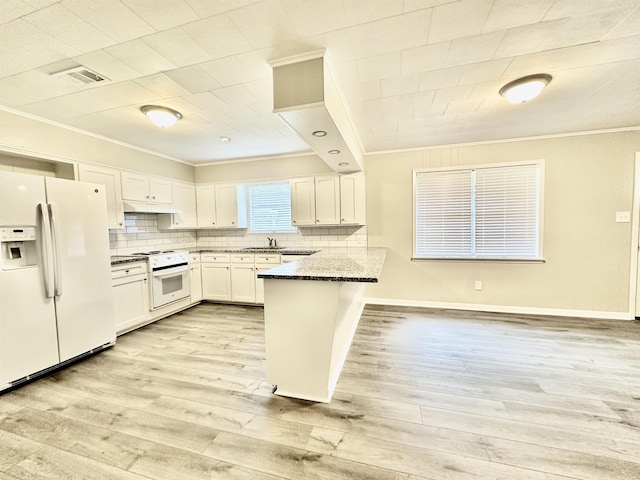 kitchen featuring white appliances, dark stone counters, white cabinets, ornamental molding, and kitchen peninsula