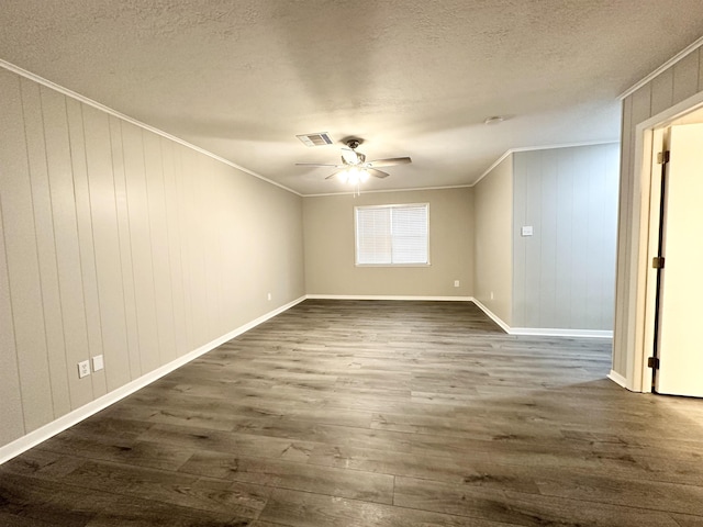 spare room featuring crown molding, ceiling fan, dark wood-type flooring, and a textured ceiling