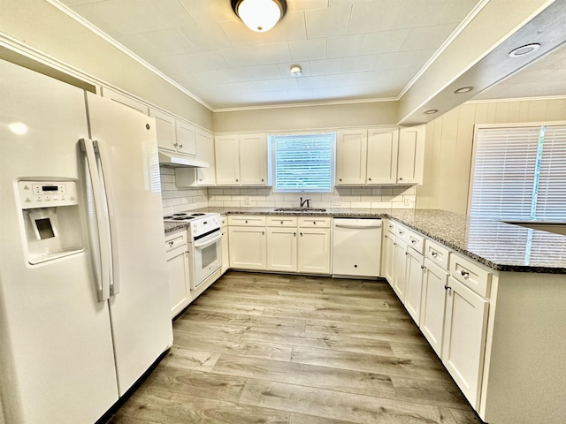 kitchen with white appliances, dark stone counters, sink, light wood-type flooring, and white cabinetry