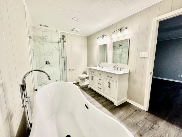 full bathroom with a textured ceiling, toilet, hardwood / wood-style flooring, vanity, and ornamental molding