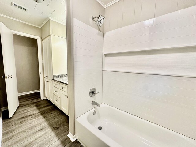 bathroom featuring hardwood / wood-style floors, vanity, shower / bathtub combination, and ornamental molding