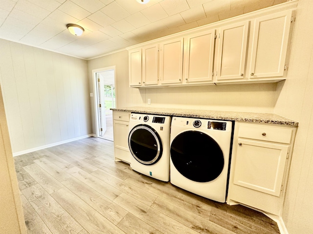 washroom with cabinets, light hardwood / wood-style flooring, and washer and dryer