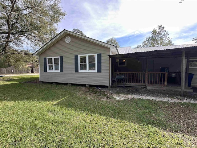 rear view of property featuring a lawn