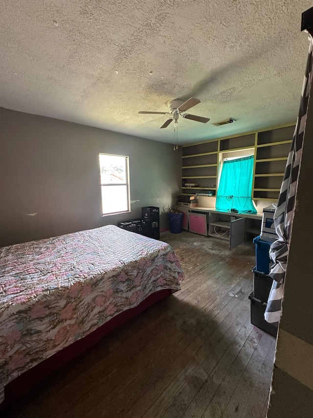 bedroom featuring a textured ceiling, ceiling fan, and dark wood-type flooring