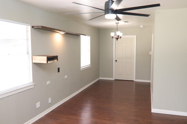 empty room featuring dark wood-style floors, visible vents, ceiling fan, and baseboards