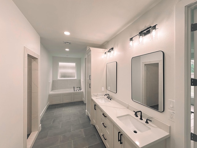 bathroom featuring tile patterned flooring, vanity, and a bathing tub