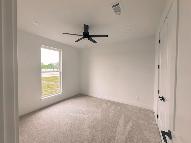 carpeted spare room featuring ceiling fan