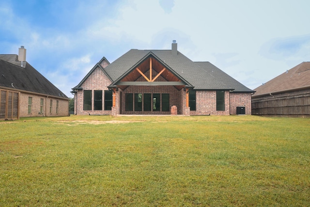 rear view of property featuring a yard and cooling unit