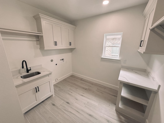 laundry area featuring cabinets, hookup for a gas dryer, sink, hookup for a washing machine, and light hardwood / wood-style flooring