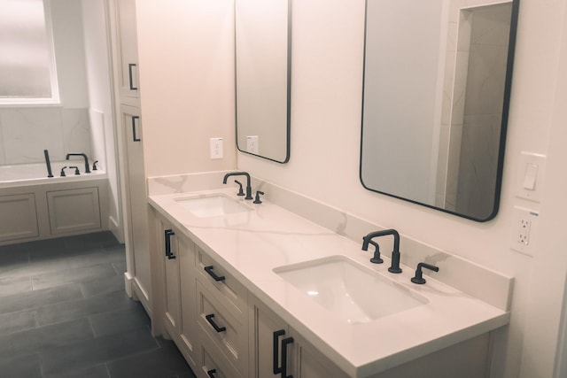 bathroom with tile patterned flooring, a bathtub, and vanity