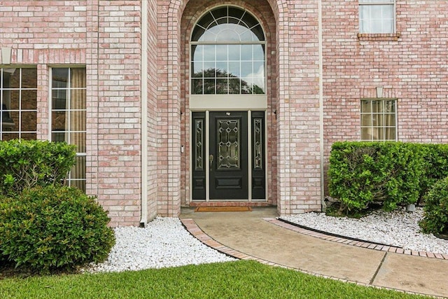 doorway to property featuring brick siding