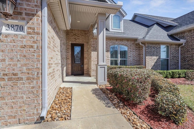 property entrance with brick siding and a shingled roof