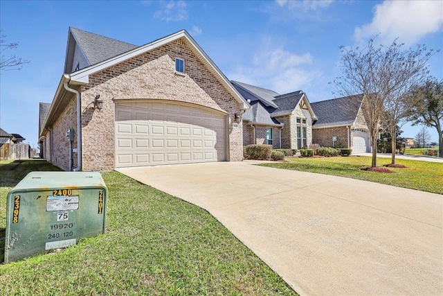 french country inspired facade featuring a front lawn, a garage, brick siding, and driveway