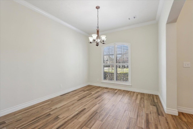 unfurnished room with baseboards, a notable chandelier, ornamental molding, and light wood finished floors