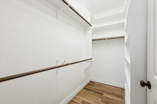 walk in closet with wood finished floors