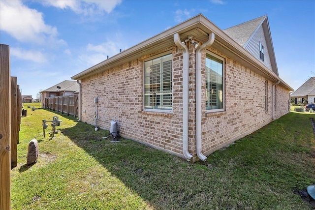 view of side of property with a yard and brick siding