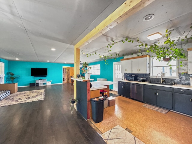 kitchen featuring dishwasher, light countertops, decorative backsplash, wood finished floors, and a sink