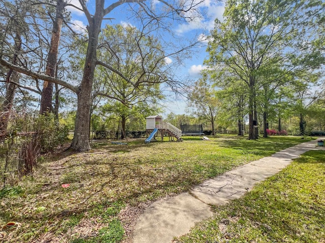 view of yard featuring a playground and a trampoline