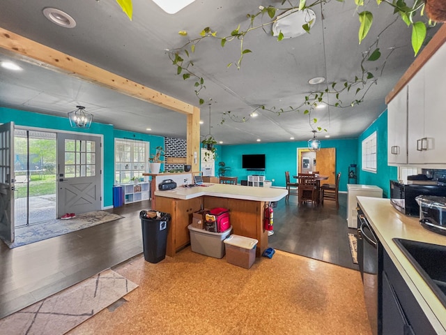 kitchen featuring open floor plan, white cabinetry, black microwave, light countertops, and dishwasher