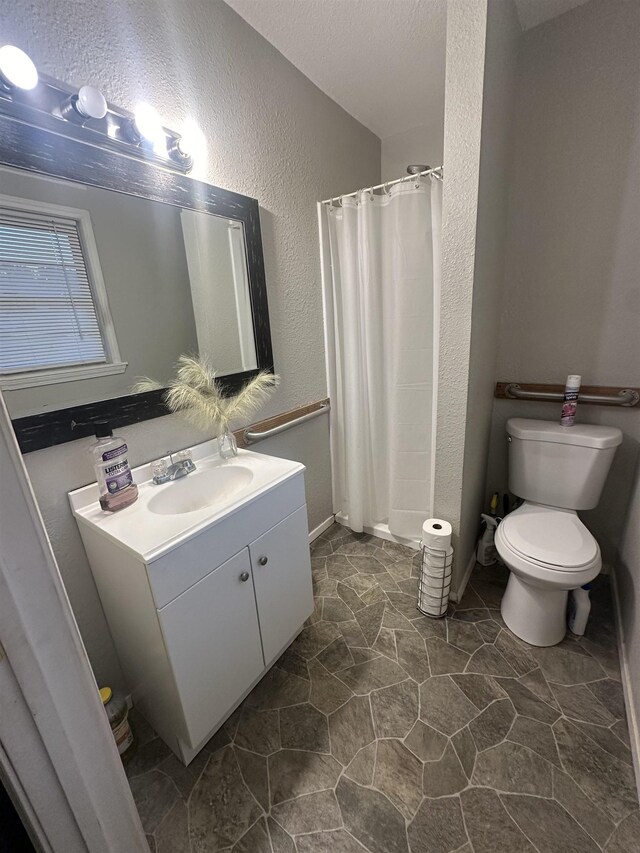 bathroom with vanity, a shower with shower curtain, a textured ceiling, and toilet