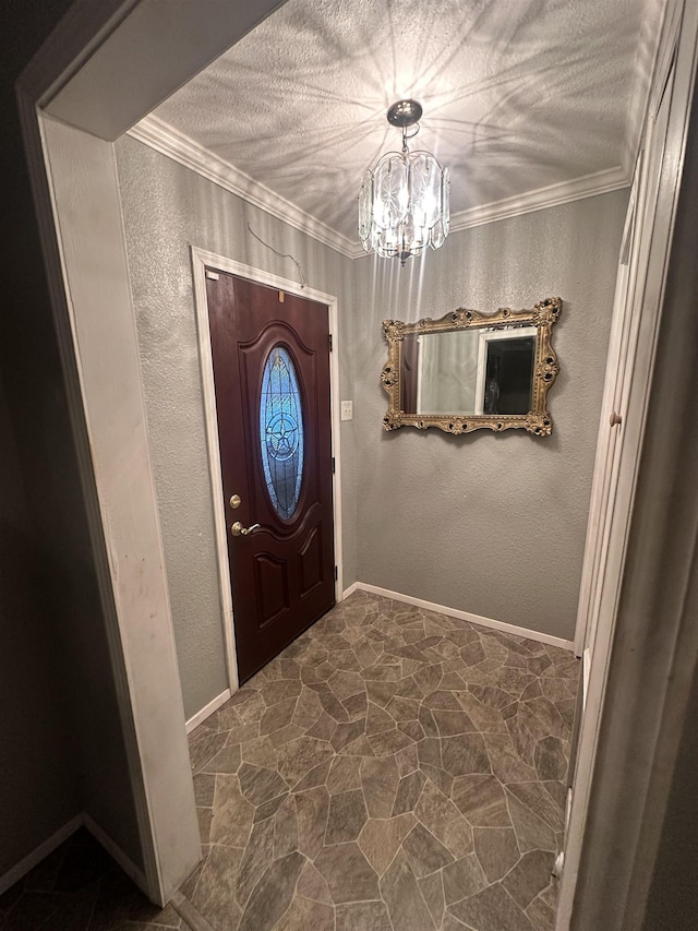 foyer entrance with a textured ceiling, an inviting chandelier, and ornamental molding