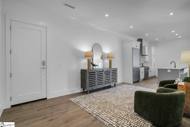 living room featuring dark hardwood / wood-style floors, ornamental molding, and sink