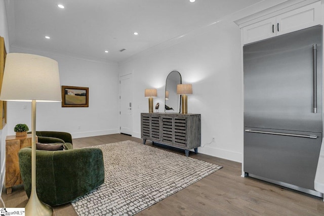 living area with crown molding and light hardwood / wood-style flooring