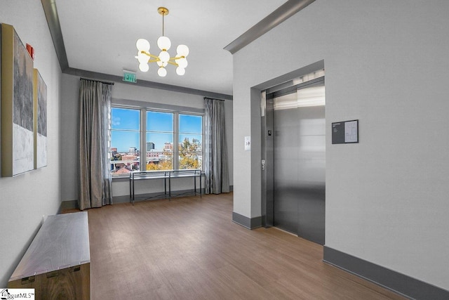 dining space with elevator, a chandelier, and dark hardwood / wood-style floors