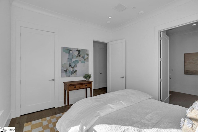 bedroom with dark hardwood / wood-style flooring and ornamental molding