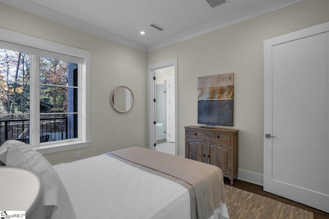 bedroom featuring ornamental molding, dark wood-type flooring, and connected bathroom