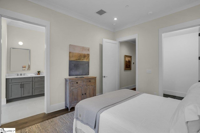 bedroom with ensuite bathroom, dark hardwood / wood-style flooring, sink, and crown molding