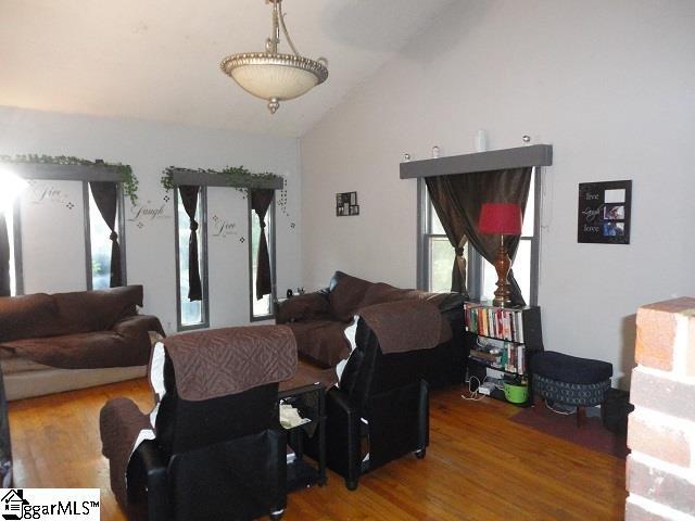 living room with hardwood / wood-style floors and vaulted ceiling