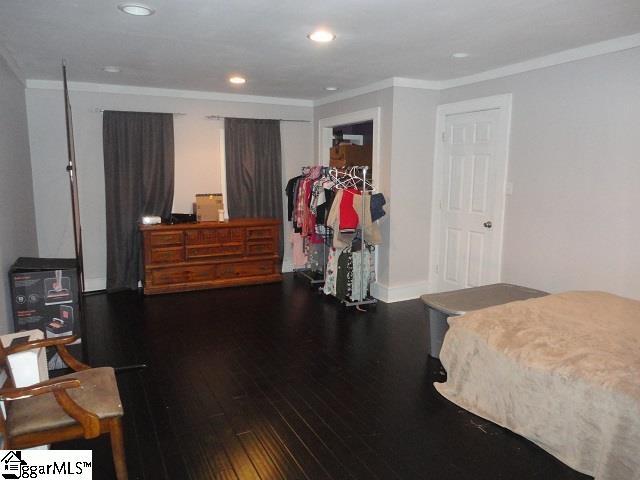 bedroom with dark hardwood / wood-style flooring and crown molding