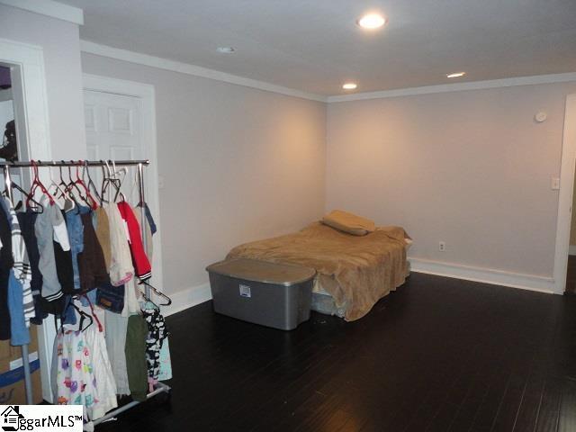 bedroom featuring dark wood-type flooring and ornamental molding